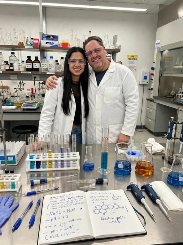 Carlos en laboratorio químico con tubos de ensayo